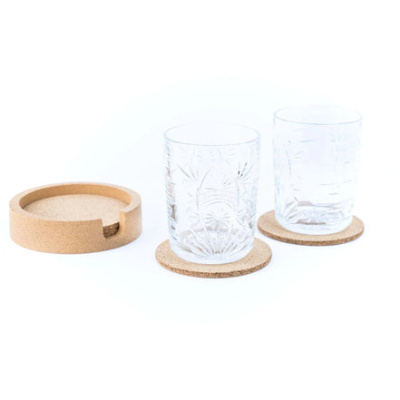 Two clear glass tumblers with cork coasters on a white background