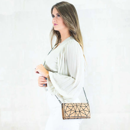 Woman wearing cork geometric crossbody wallet with chain strap over shoulder