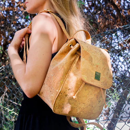 Woman wearing the golden vegan cork drawstring backpack outdoors