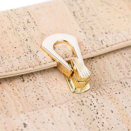 Close-up gold turn-lock clasp on natural cork vegan handbag.  Shown in black only available in natural