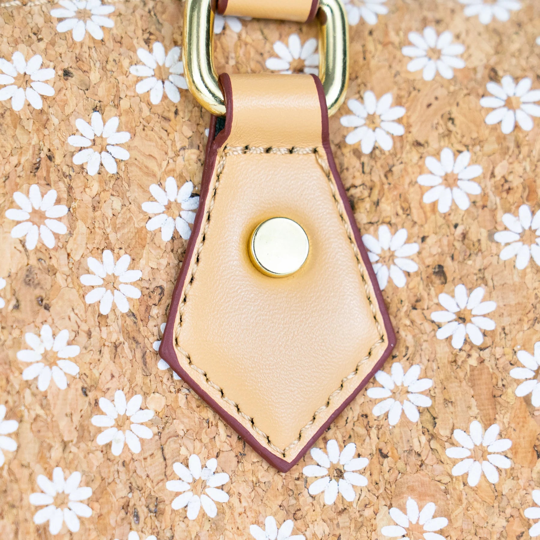 Close-up of floral cork printed surface and leather strap hardware