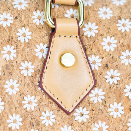 Close-up of floral cork printed surface and leather strap hardware