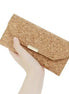 Hand holding natural cork RFID wallet with gold clasp and tri-fold design