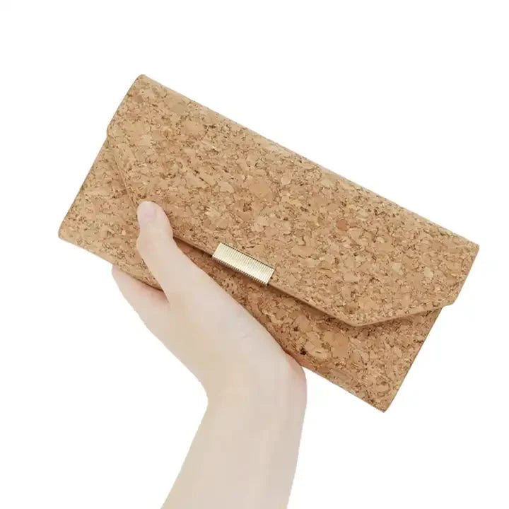 Hand holding natural cork RFID wallet with gold clasp and tri-fold design