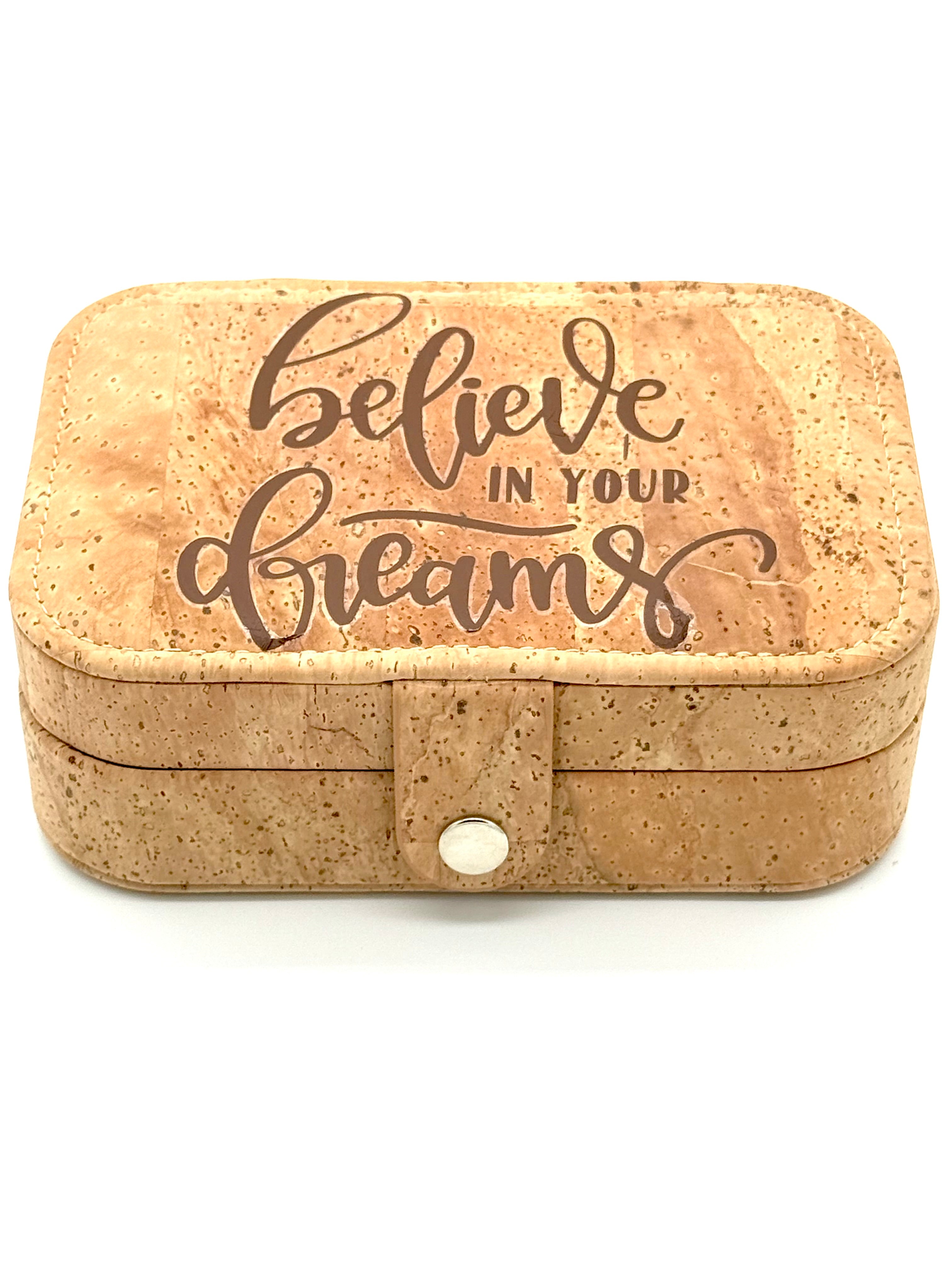 Cork jewelry box with 'believe in your dreams' text on a white background