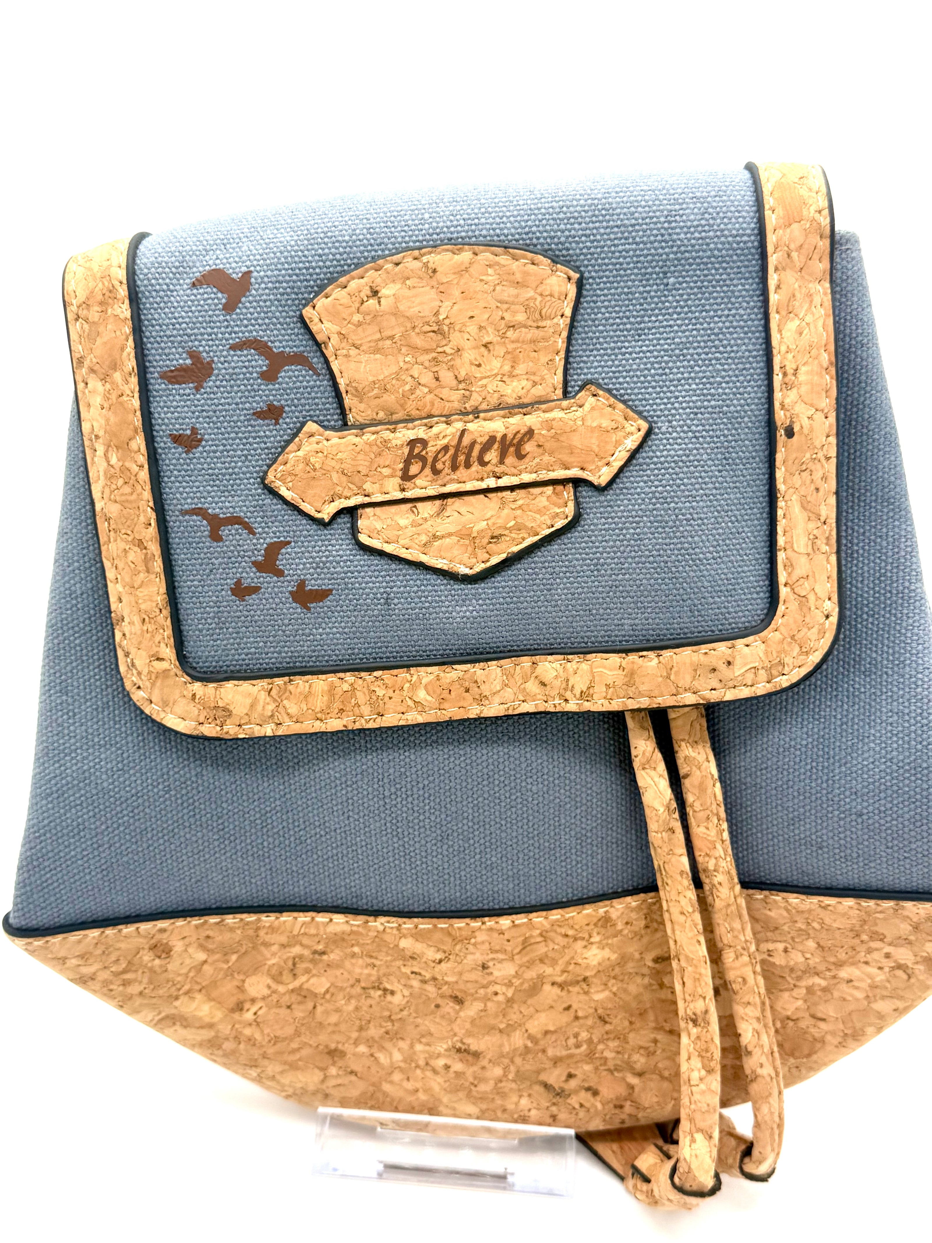 Blue pouch with cork accents and 'Believe' design on a white background