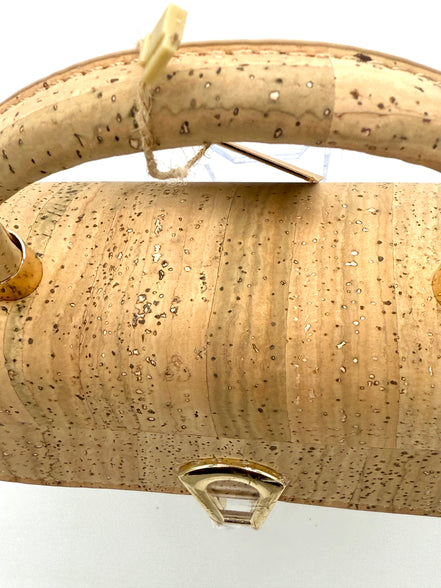 Beige cork handbag with a gold clasp on a white background