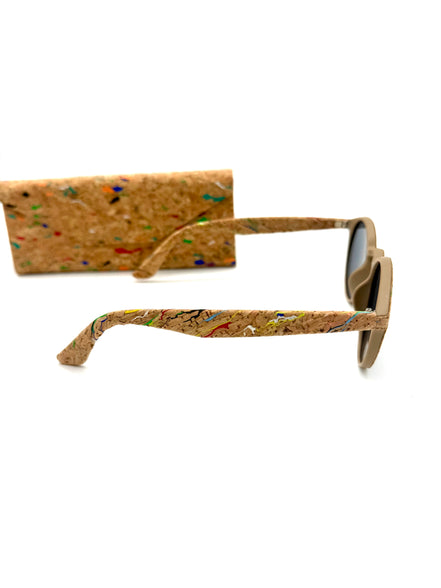 Cork sunglasses resting beside matching multicolor cork case
