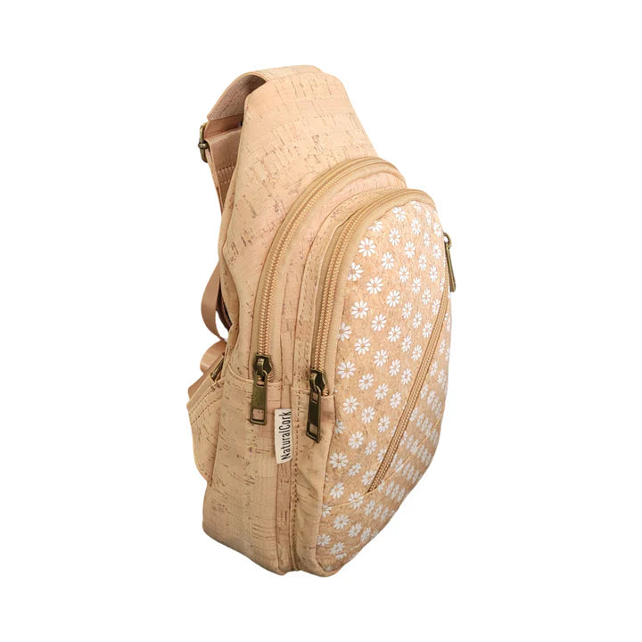 Daisy print cork sling bag shown at an angle featuring front zipper and compact design.