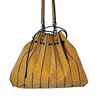 Side angle of cork tote showcasing laser cut pleats and drawstring detail